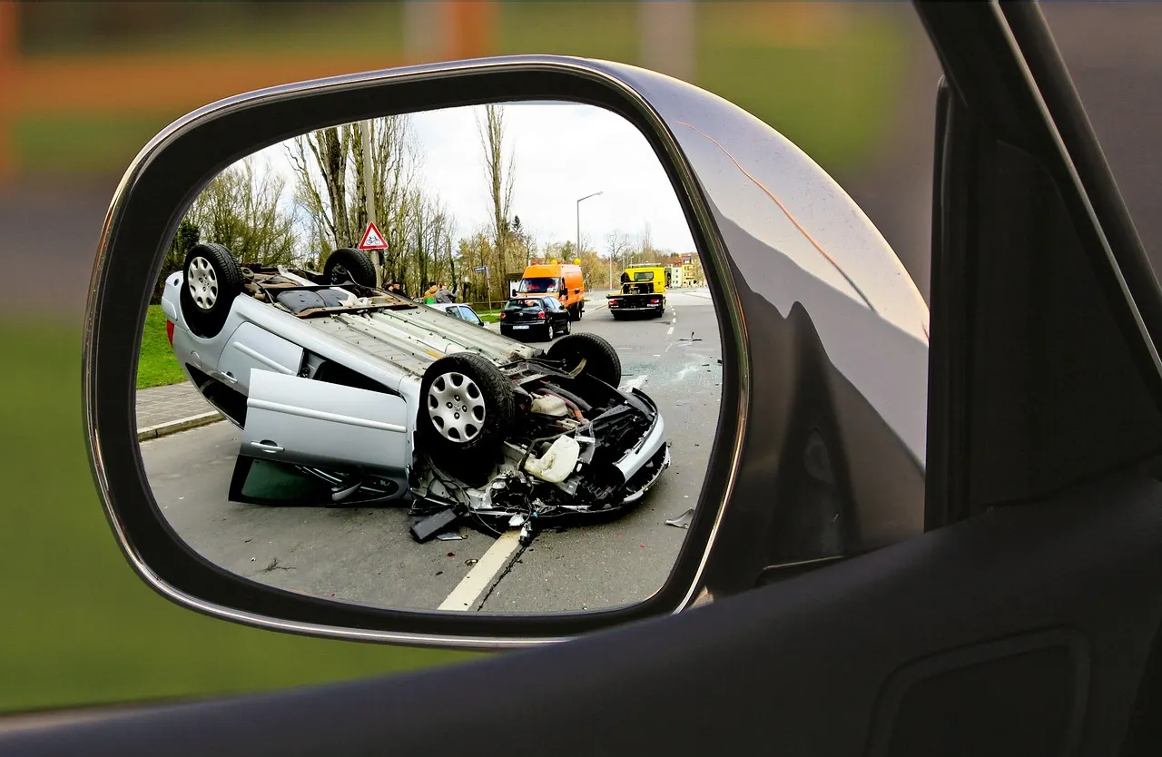 Accident scene reflected in a car side mirror